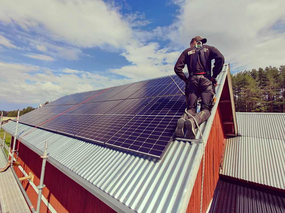 Byggevallens Elservices medarbetare håller på med något på ett tak.