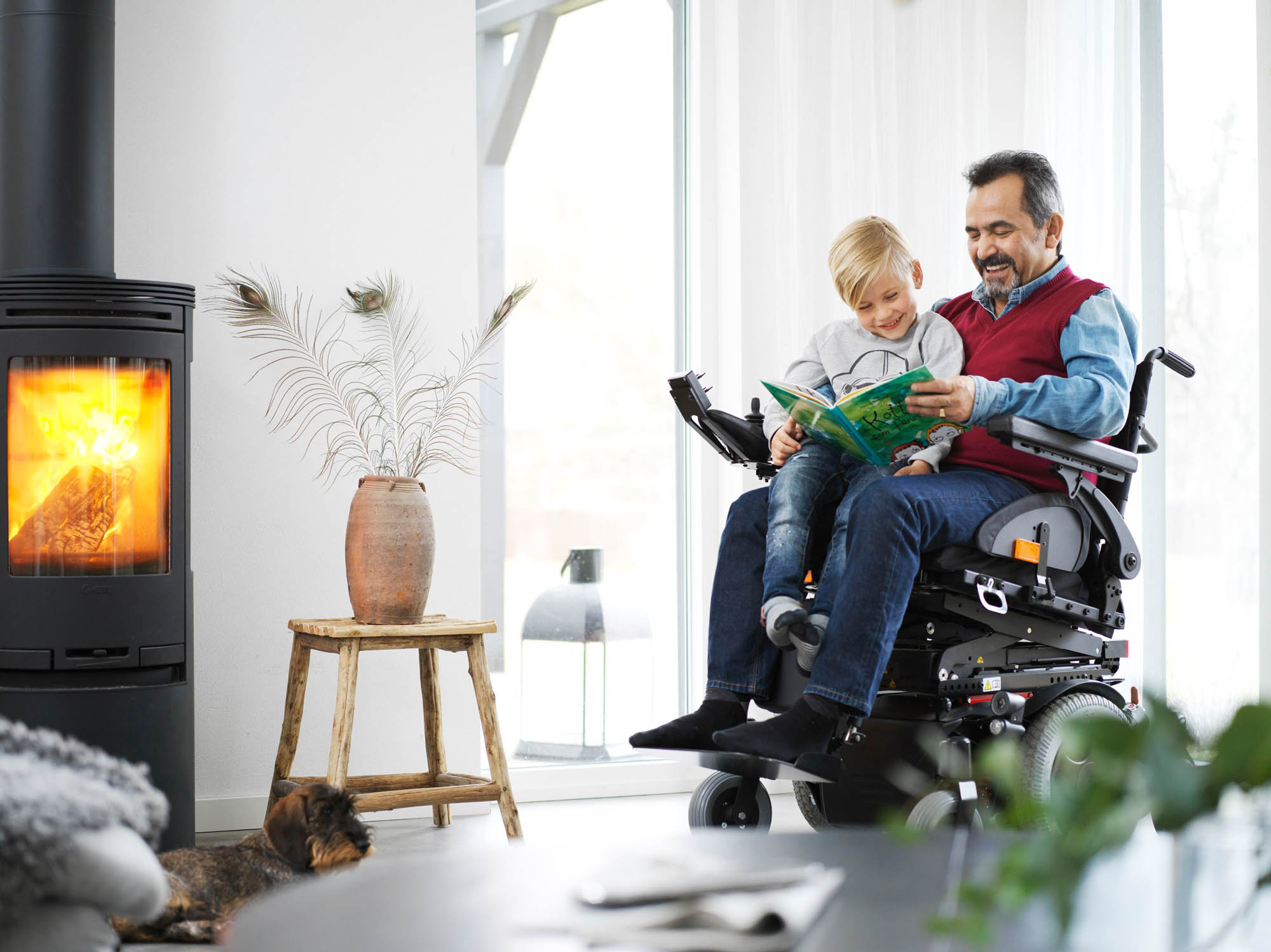 En man i rullstol läser upp barnböcker för ett barn.